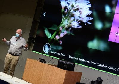 Pietro Perona standing next to his presentation slide featuring flowering plant